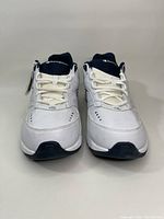 Front view of the pair of white Champion sneakers with black accents, showing lace-up closure and brand logo on tongues.