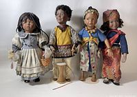 Front view of four porcelain dolls standing; details of costumes and accessories visible