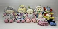 Full view of all seven Vidalia Onion Babies dolls lined up in seated position, showing various clothing and features.