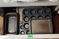 Drawer with the loaf pan, muffin pan, and two baking pans stacked inside