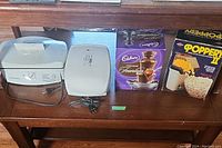 Photo showing all four items side-by-side: double grill, single grill, chocolate fondue box, popcorn popper box.