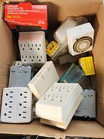 Photo of electric accessories including outlets, timer switch, switch plates, electrical boxes, and pivot siding clip box.