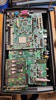Overhead photo showing a box filled with several computer and network main boards stacked together for material recovery.