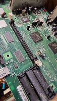 Close-up view of a circuit board showing integrated circuits, connectors, and other electronic components for salvage.