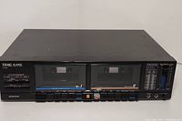 Front view of the Teac W-440C stereo double cassette deck showing dual cassette slots, control buttons, and branding.