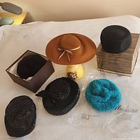 Six vintage women’s hats displayed together showing variety of styles and colors including felt, fur, sequin, woven, and knit.