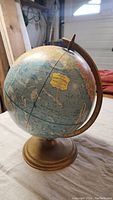 Full view of the 12 inch globe showing world geography with gold metallic stand and meridian ring.
