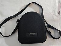 Closed black hard carrying case with Bose logo and shoulder strap.
