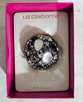 Liz Claiborne spherical paperweight with multicolored rhinestones in original box with pink interior and white insert labeled 'Liz Claiborne Paperweight'.