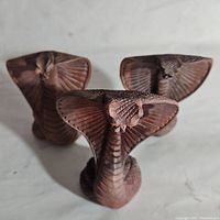 Three mini hand carved wooden cobra figurines shown together, highlighting size and details