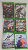 Photo of six Xbox One game cases including Gears of War Ultimate Edition, Watch Dogs, Lego The Hobbit, Grand Theft Auto V, Madden NFL 16, and Battlefield V
