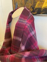 Wool scarf draped on mannequin showing the rich plaid check pattern in fuchsia, violet, and lilac tones.