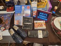 Lot overview showing women's shoes, grooming kits, telephone, book, digital calendar and box of patches.