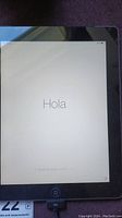 Apple iPad screen showing initial setup greeting in Spanish 'Hola'.