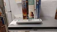 Sony CD/DVD player with DVDs and remote on top