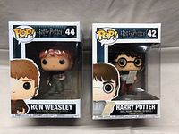 Photo of boxed Ron Weasley (#44) and Harry Potter (#42) Funko Pop figures from the front.