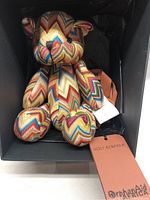 Full view of the Holt Renfrew Mission Bear sitting inside a black box with Holt Renfrew and Orphan Aid tags visible.