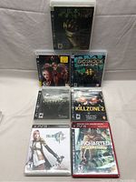 Photo showing all 7 PS3 games in their cases arranged on a flat surface.
