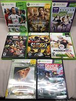 Front view of all 8 Xbox 360 game cases arranged in two rows of four, showing full cover artwork and some price stickers.