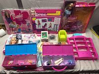 Photo showing assortment of Barbie accessories including doll furniture, carrying cases with small items, boxed sets, and loose pieces.