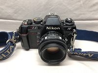 Front view of Nikon N2020 camera with lens and Nikon blue strap