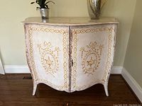 Front view of painted cabinet showing two doors and gold motifs