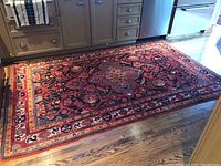 Full-width view of carpet in kitchen showing overall pattern, colors and one corner binding detached