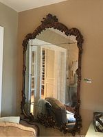 Full frontal view of the large ornate mirror mounted on wall