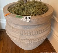 Side view of the concrete planter showing rope trim detail and moss inside.