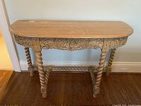 Full front view showing light-colored wooden sofa/hall table with intricately carved apron and twisted column legs