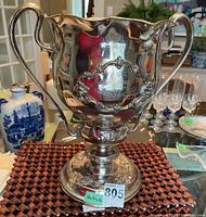 Full front view of the trophy showing handles, decorative cartouche, and engraved plaque