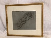 Framed charcoal drawing with visible gold wooden frame and white matting, showing the full artwork and frame.
