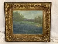 Frontal view of the oil painting in an ornate gold frame showing the bluebonnets landscape and signature.