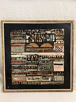 Frontal view of the framed abstract oil painting showing geometric shapes, text and patterns.