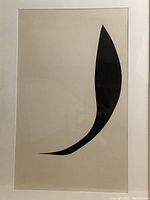 Close-up photo of the black cut-out collage artwork by Richard I. Brooker showing the abstract single curved black shape on a light background.