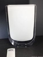 Front view of tall white and clear rectangular glass vase with flat top and rounded edges.