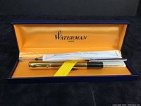Pen capped inside open Waterman box, satin orange liner and paperwork visible