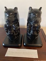 Pair of black carved indigenous Boma bookends side by side with a note describing the items as Vintage Indigenous Boma Bookends from Canada, measurements 7.5 inches.