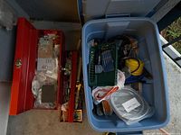 Photo of red metal toolbox with tools inside alongside blue plastic tote filled with miscellaneous hardware items