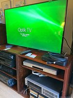 TV on wooden stand with video components