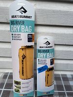 Photo of sealed packaging of two Sea to Summit Big River Dry Bags: one 20L and one 5L, both yellow, waterproof, heavy duty with lash loops.