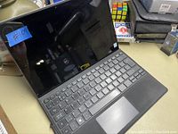 Acer laptop computer showing keyboard, touchpad, and screen. No power cord included. Screen is off, reflecting surroundings.