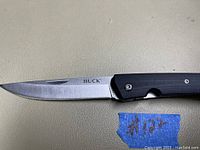 Close-up of the Buck logo engraved on the blade, showing condition and detail.