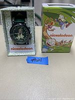 Nickelodeon wristwatch displayed in original decorative box alongside the colorful packaging box featuring cartoon characters.