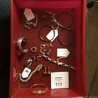 Full view of tray containing bracelets, rings, tie tacs, and cuff links.