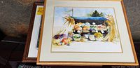 Framed watercolor painting by Judy McLaren featuring colorful fruits and vegetables in an outdoor market setting.