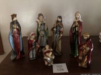 Full view of all eight nativity scene porcelain figurines arranged on table.