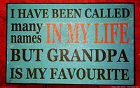 Green wooden plaque with engraved text "I HAVE BEEN CALLED MANY NAMES IN MY LIFE BUT GRANDPA IS MY FAVOURITE"