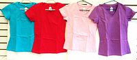 Four T-shirts in turquoise, red, baby pink, and purple displayed on hangers