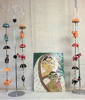Full lot view showing wrapped painting on wood and three fabric hanging ornaments